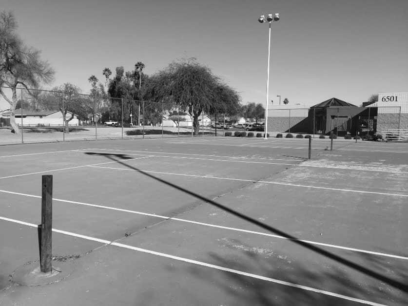 Black and white photo of an unused tennis court